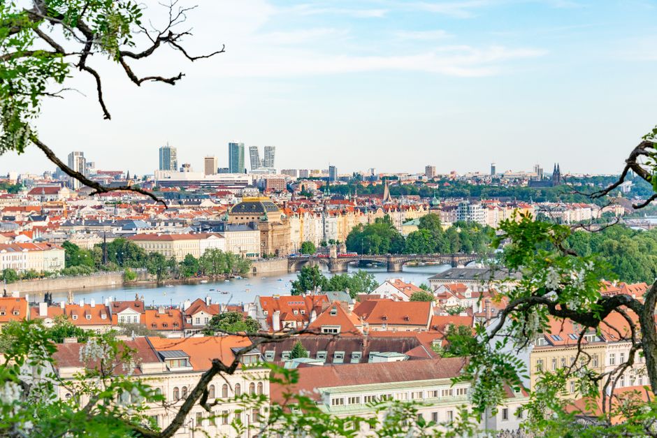 A beautiful aerial shot of Prague showcasing historic architecture and lush greenery along
