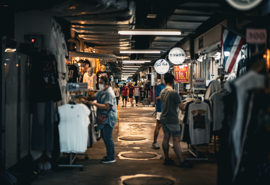 A bustling Bangkok night market with shoppers in a lively atmosphere.