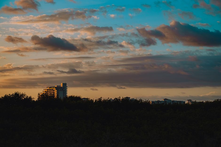 Capture of an urban skyline at dusk with dramatic clouds and a colorful sky.