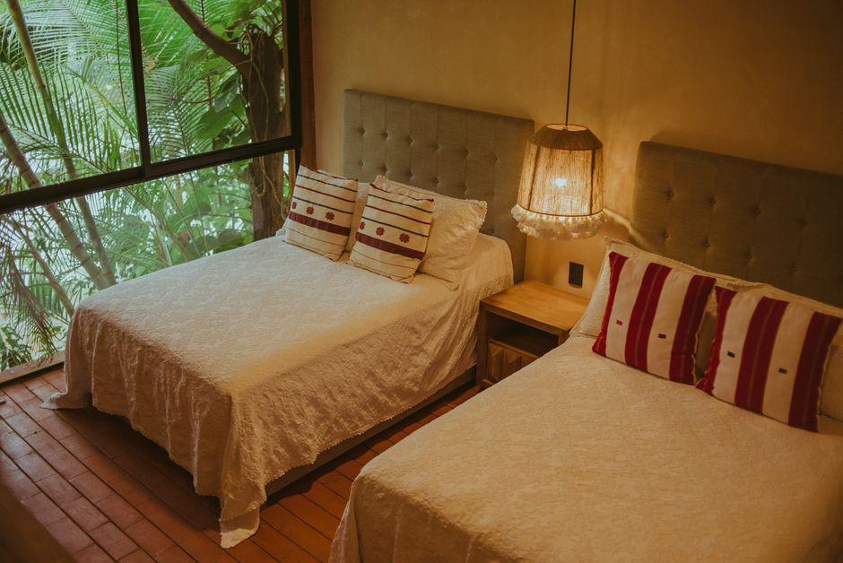 Inviting resort bedroom featuring twin beds and a tropical window view for a relaxing stay.