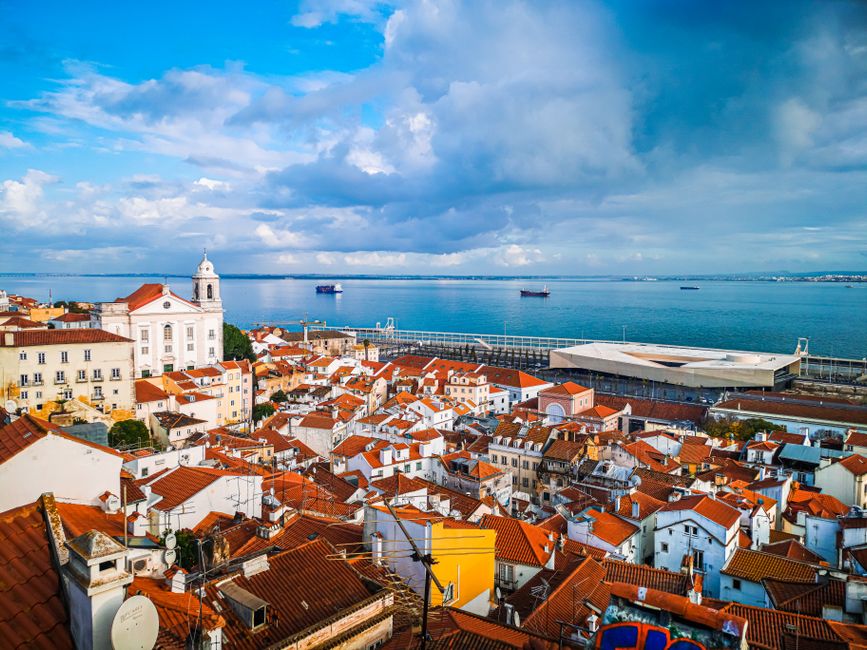 Captivating aerial view of Lisbon's historic rooftops by the scenic coastal shore.