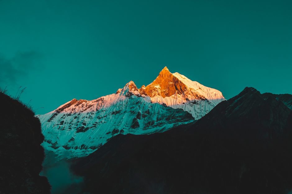 Breathtaking view of snow-capped Annapurna peaks bathed in sunrise glow, Ghandruk, Nepal.