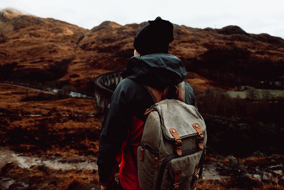 Adventure awaits as a backpacker explores the scenic highlands, embracing the cold wilderness.