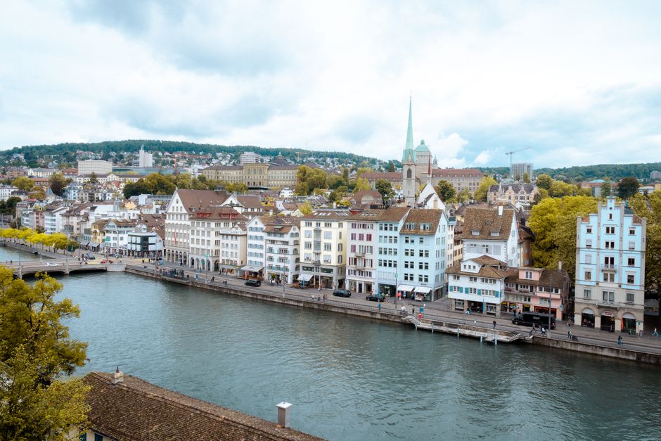 A picturesque view of Zurich's historic buildings along the Limmat River on a cloudy day.