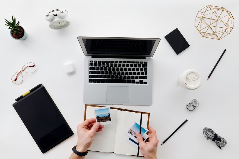 A top view of a minimalistic home office setup featuring a laptop, tablet, and accessories.