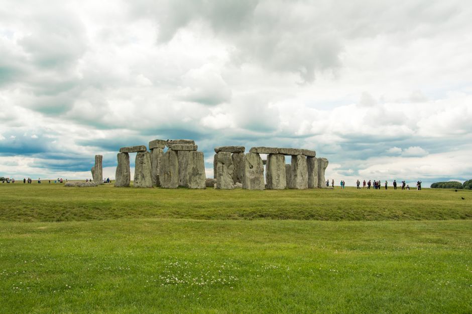 Stonehenge with tourists under cloudy skies showcasing the iconic landmark in England.