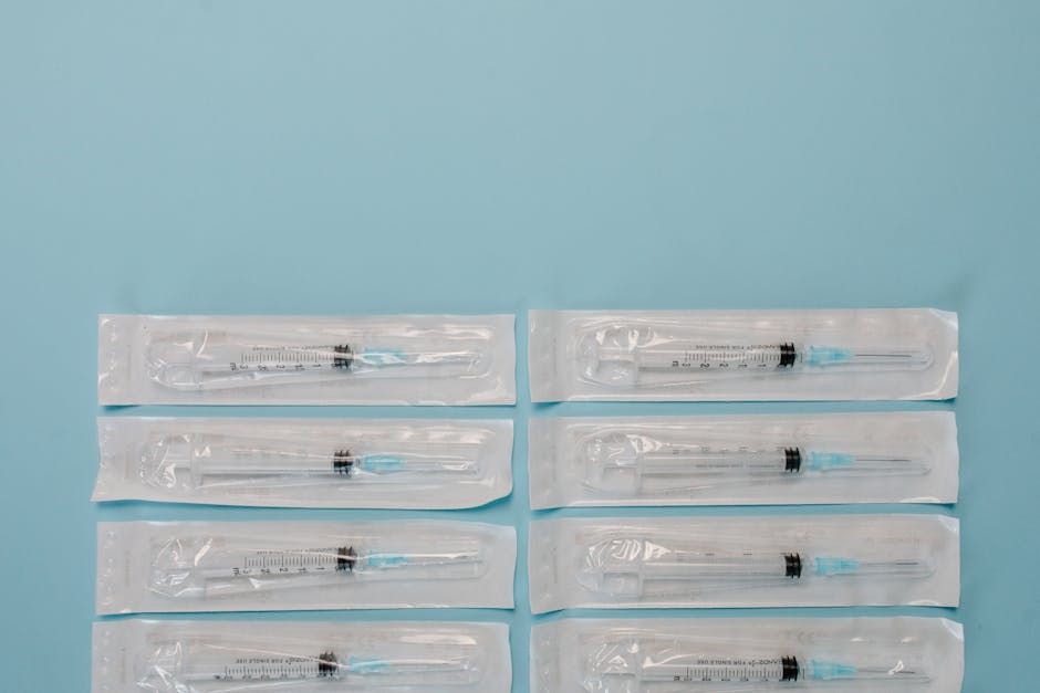 Top view of sterile packaged syringes arranged on a blue background for medical use.